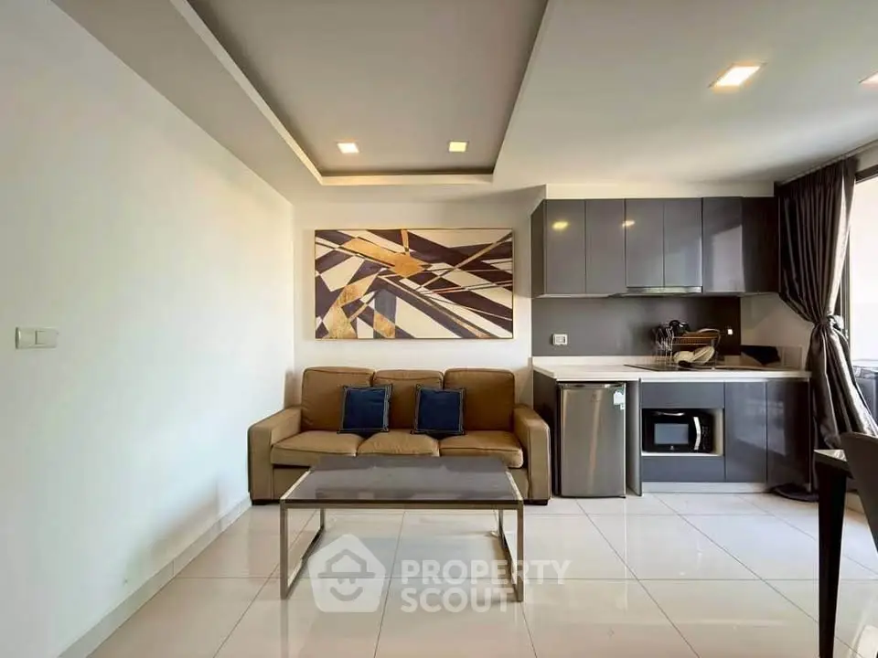 Modern living room with sleek kitchen, stylish decor, and natural light.