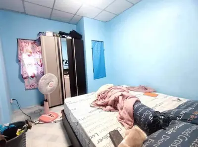 Cozy bedroom with blue walls, wardrobe, and fan, perfect for relaxation.