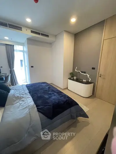 Modern bedroom with stylish decor and natural light in a contemporary apartment.