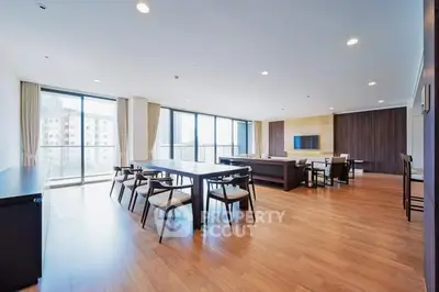 Spacious modern living room with large windows and elegant wooden flooring.