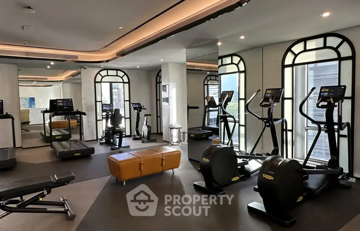 Luxurious gym with modern fitness equipment and elegant design in upscale residential building.