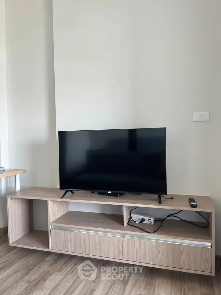 Modern living room with sleek TV stand and flat-screen TV, perfect for entertainment.