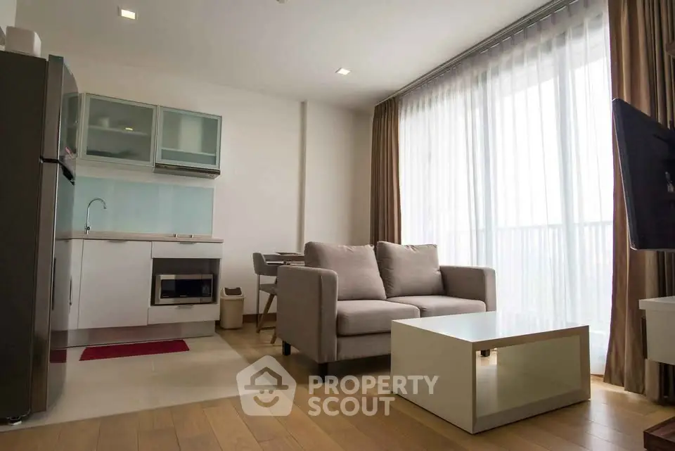 Modern living room with open kitchen and large windows in a stylish apartment