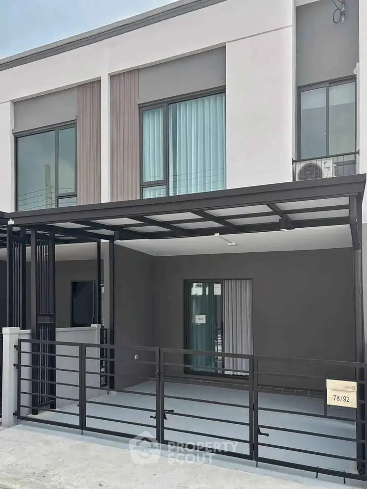 Modern townhouse exterior with sleek design and gated entrance, perfect for urban living.