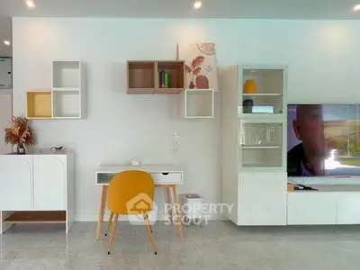 Modern living room with stylish furniture and wall-mounted storage, featuring a sleek TV setup.