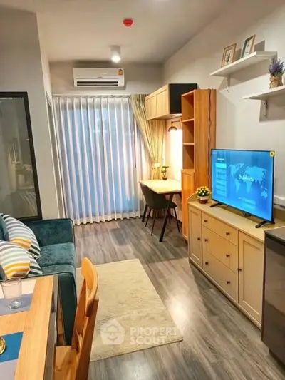 Modern living room with cozy decor and natural light, featuring a TV and study area.