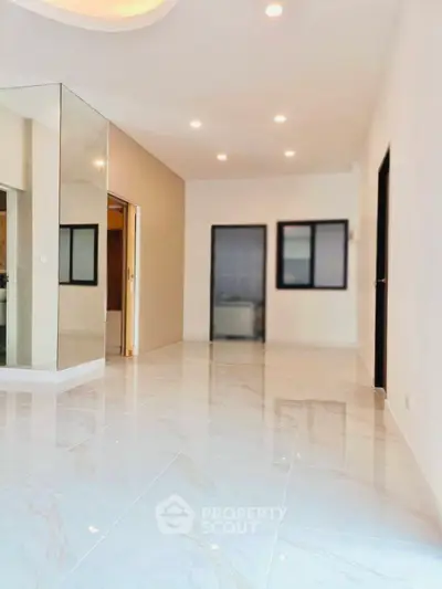 Spacious modern living room with glossy tile flooring and recessed lighting