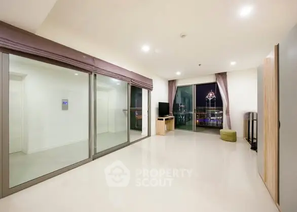 Spacious modern living room with large windows and city view.