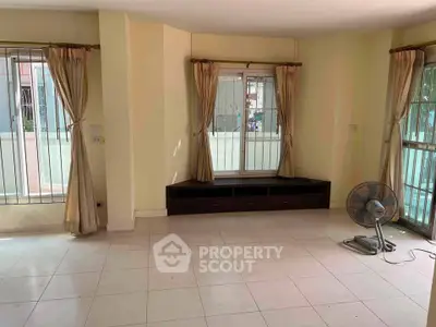 Spacious living room with large windows and natural light, perfect for relaxation and entertaining.