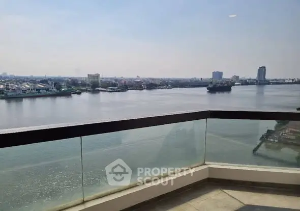 Stunning river view from a modern balcony with glass railing, perfect for relaxation and enjoying the scenery.