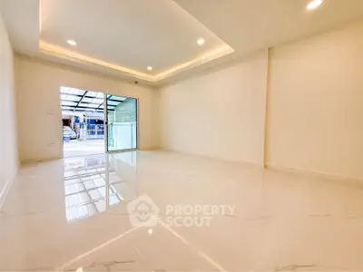 Spacious modern living room with glossy floors and large sliding glass doors.