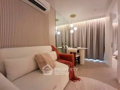 Modern living room with elegant decor, featuring a cozy sofa, stylish lighting, and a chic dining area.