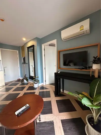 Stylish living room with modern decor and air conditioning, featuring a sleek TV setup and elegant flooring.