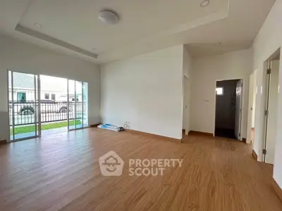 Spacious living room with wooden flooring and large windows in modern home