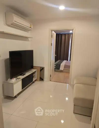 Modern living room with sleek TV setup and cozy bedroom view