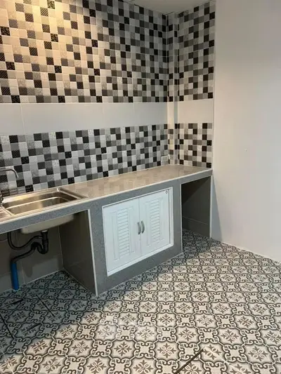 Stylish kitchen with modern tile design and sleek countertop, perfect for culinary enthusiasts.