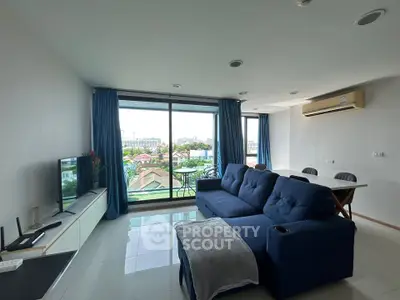 Spacious living room with modern decor and large windows offering city views.