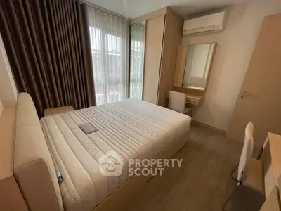 Modern bedroom with natural light, featuring a comfortable bed, air conditioning, and stylish furnishings.