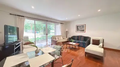 Spacious living room with elegant decor and large windows overlooking a lush garden.