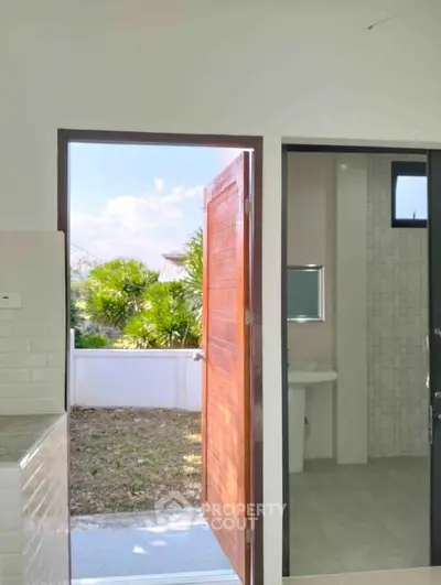 Charming bathroom with outdoor access, featuring modern fixtures and natural light.