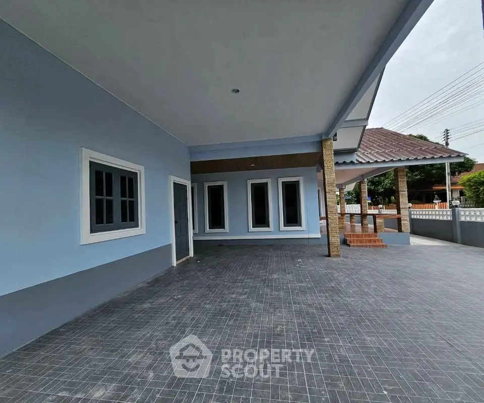 Spacious modern home exterior with covered patio and tiled flooring, perfect for outdoor gatherings.