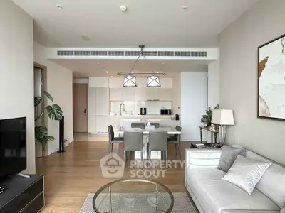 Modern living room with open kitchen, elegant decor, and natural light