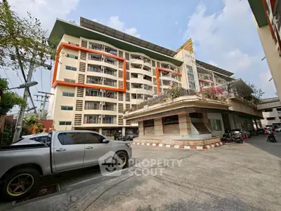 Modern multi-story building with unique architectural design and spacious parking area.