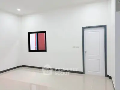 Spacious empty room with modern white walls and tiled flooring, ready for customization.
