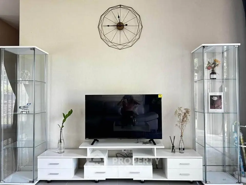 Modern living room with sleek TV stand and glass display cabinets