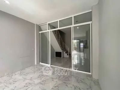 Spacious modern interior with marble flooring and glass partition, ideal for open living spaces.