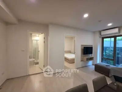 Modern apartment interior with open living area, bedroom, and bathroom, featuring sleek design and natural light.