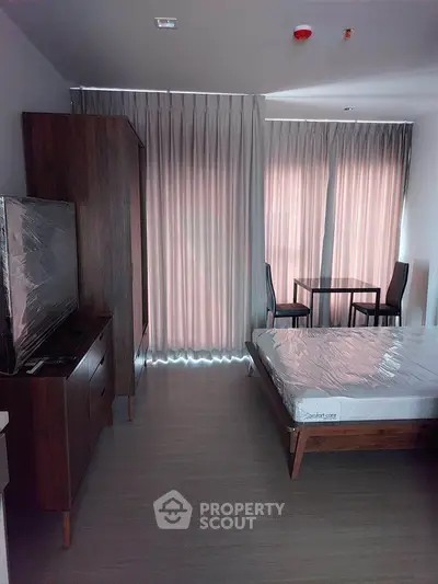 Modern studio apartment with sleek furniture and large windows for natural light.