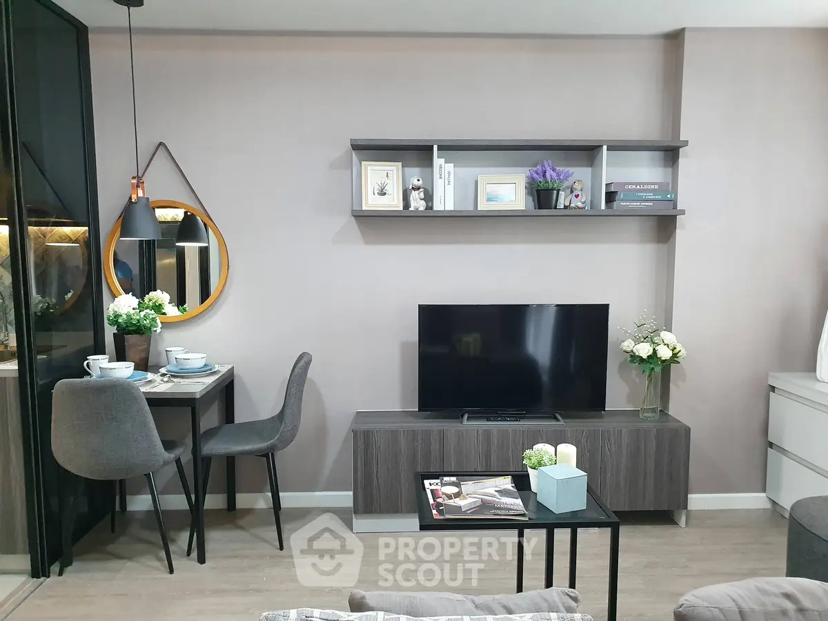 Modern living room with stylish decor, TV unit, and cozy dining area in a contemporary apartment.