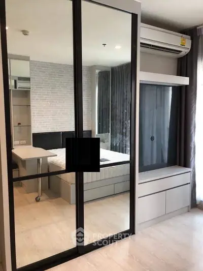 Modern bedroom with mirrored closet and air conditioning in stylish apartment.