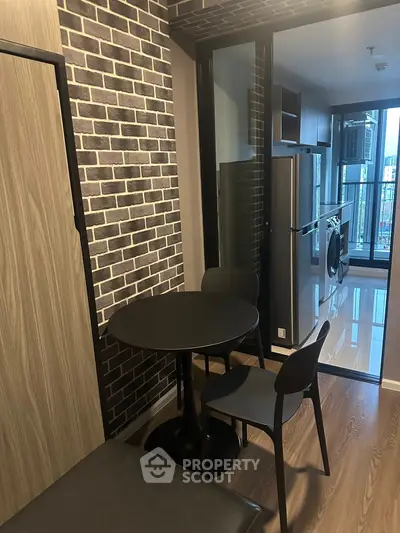 Modern kitchen with sleek appliances and stylish dining area in urban apartment.