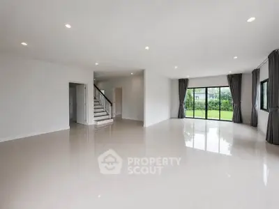 Spacious modern living room with large windows and garden view