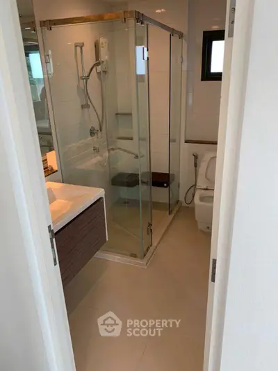 Modern bathroom with glass shower and sleek fixtures in a contemporary home.