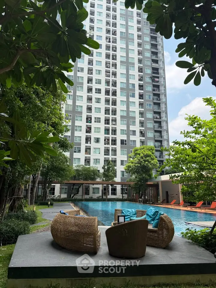 Luxurious high-rise building with poolside seating and lush greenery, perfect for modern urban living.