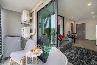 Modern apartment with cozy living room and balcony, featuring stylish furniture and natural light.