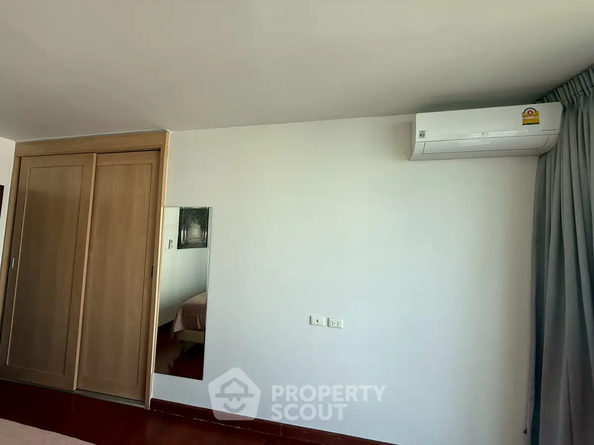 Spacious bedroom with built-in wardrobe and air conditioning unit