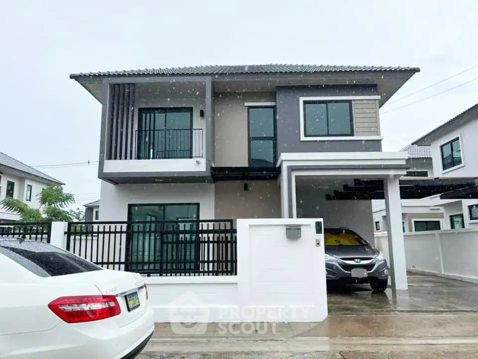 Modern two-story house with sleek design and spacious driveway in suburban neighborhood.