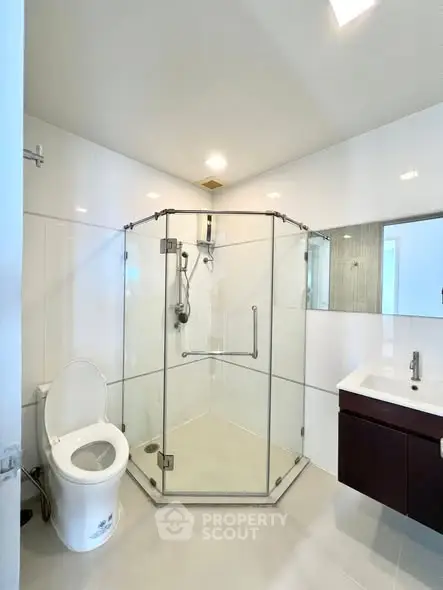 Modern bathroom with glass shower enclosure and sleek fixtures