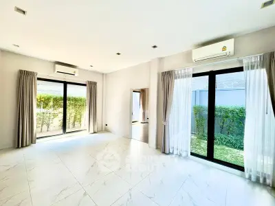 Spacious modern living room with large windows and garden view, perfect for natural light lovers.