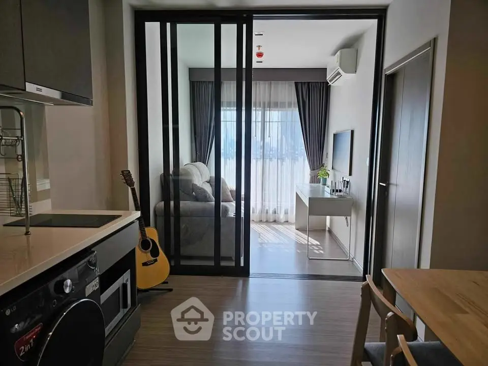Modern apartment interior with open kitchen and cozy living room, featuring stylish decor and natural light.