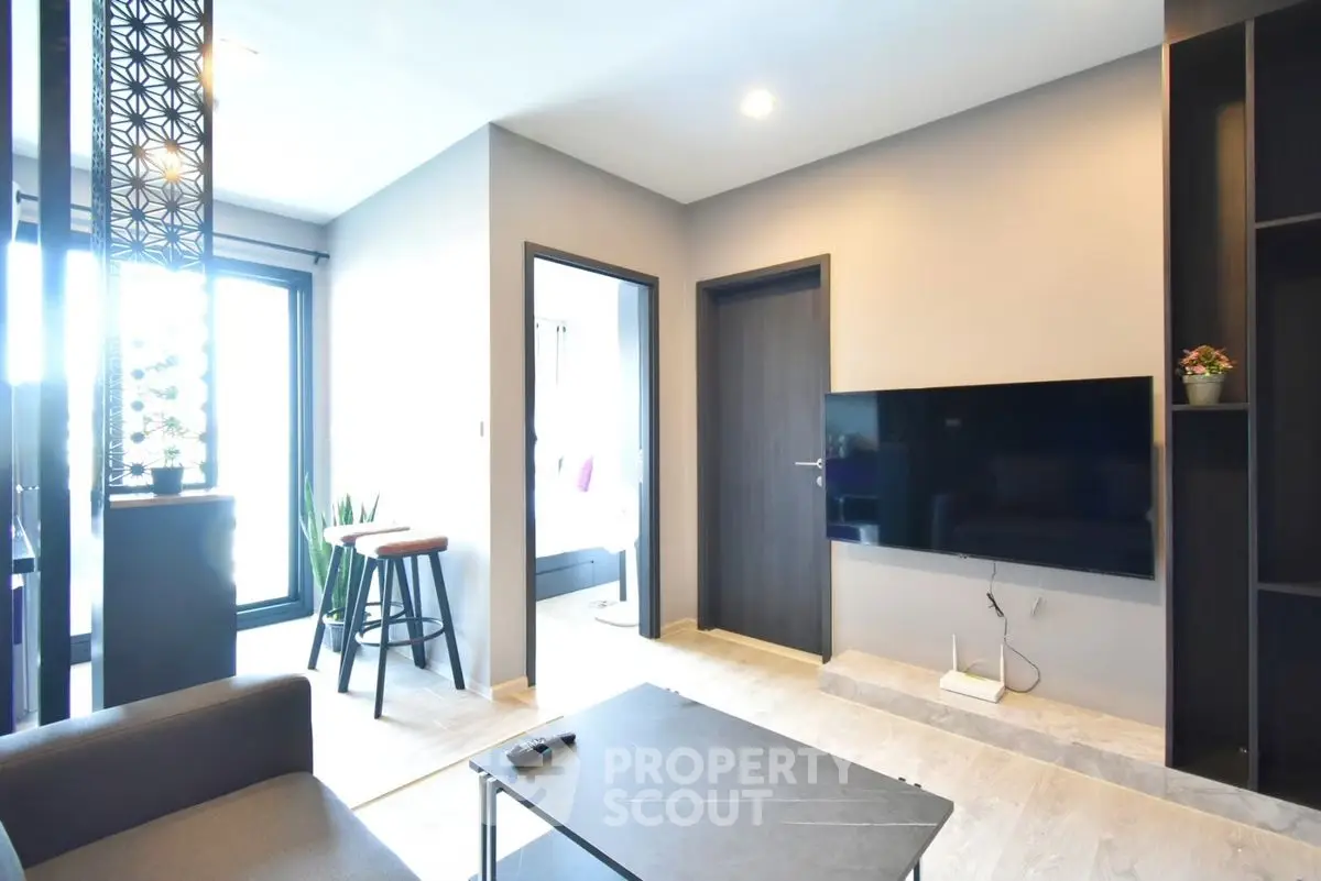 Modern living room with sleek design, wall-mounted TV, and stylish decor in a contemporary apartment.