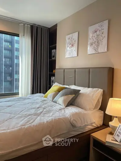 Modern bedroom with stylish decor and large window offering city views, perfect for urban living.