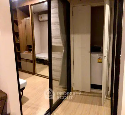 Modern apartment interior with mirrored closet and washing machine area