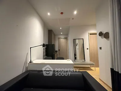 Modern living room with sleek black sofa and stylish desk in contemporary apartment.