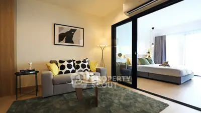 Modern living room with cozy sofa and stylish decor leading to a bright bedroom.