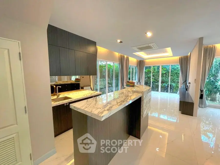 Modern open kitchen with marble island and spacious living area